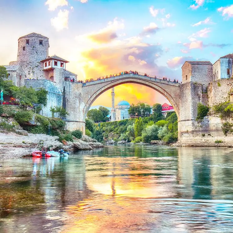 Fantastic Skyline of Mostar with the Mostar Bridge, houses and minarets, at sunset. Location: Mostar, Old Town, Bosnia and Herzegovina, Europe
